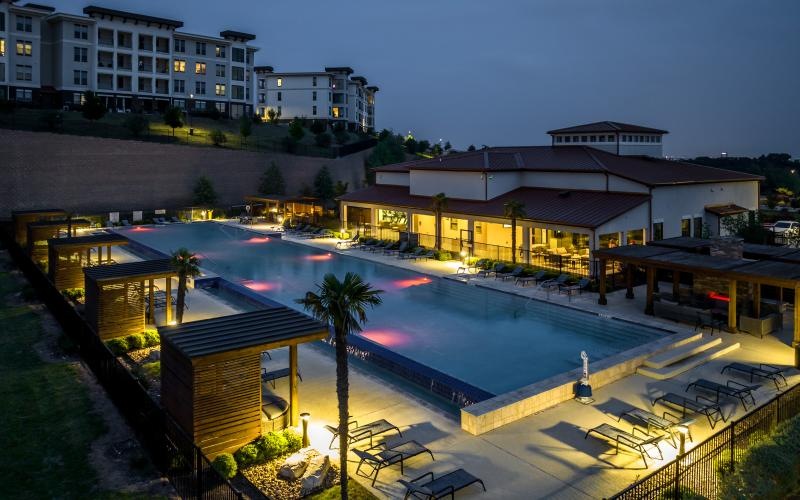 a building with a pool and a deck with a building behind it