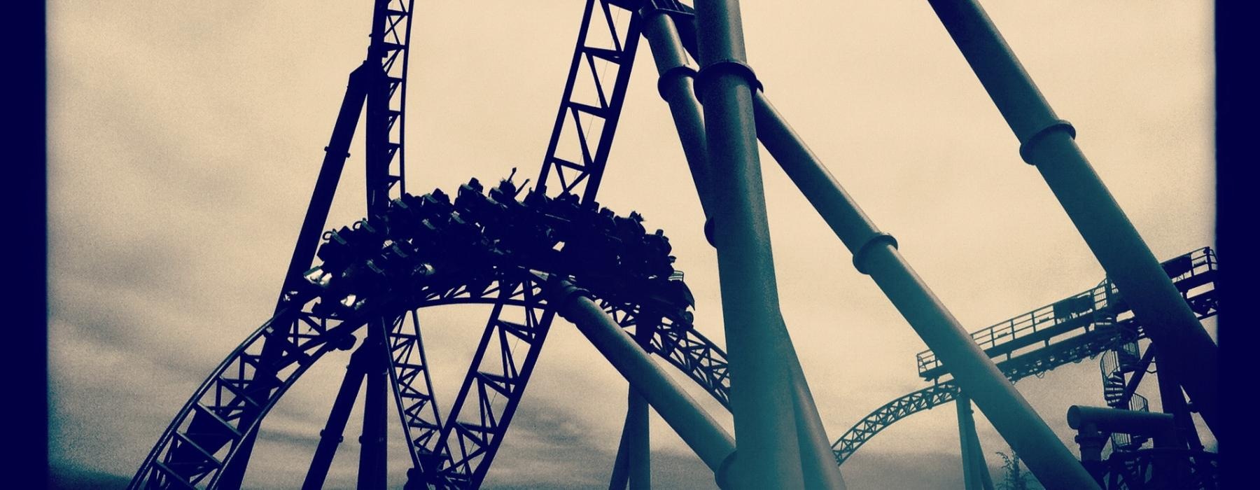 a roller coaster with a cloudy sky