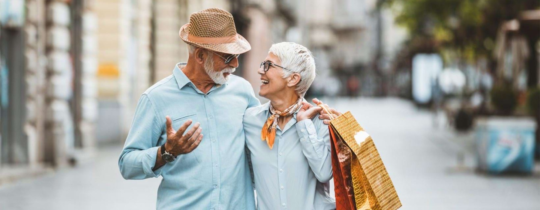 a man and woman holding shopping bags while walking